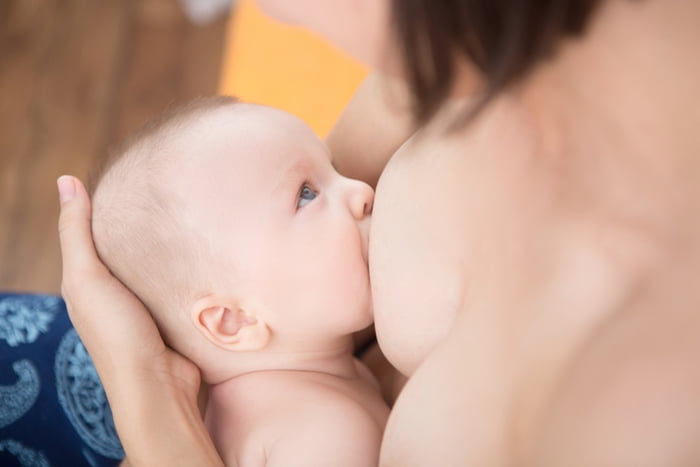 Mother is breast-feeding a newborn baby