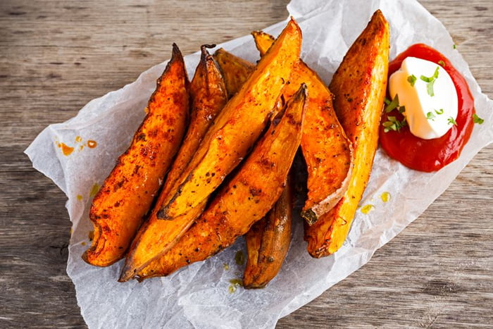 Sweet potato fries in paper wrap executed in metal serving