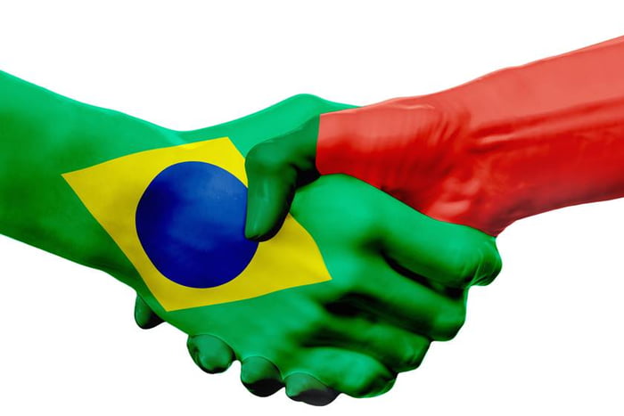 Flags Brazil, Portugal countries, partnership friendship handshake concept.