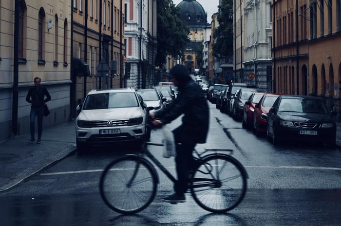 Homem pedalando na rua vazia de moletom