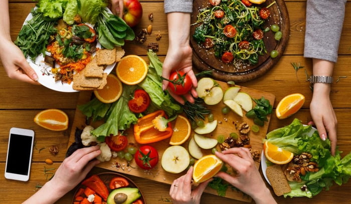Mãos com frutas, verduras e legumes, comida vegana