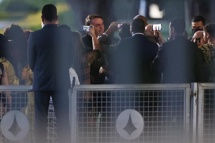 Presidente Bolsonaro chega ao palácio da Alvorada e cumprimenta apoiadores sem máscara. Os seguranças que o acompanham também não utilizam o equipamento de proteção.