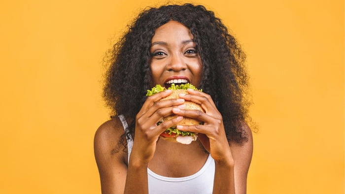 Mulher comendo um hambúrguer