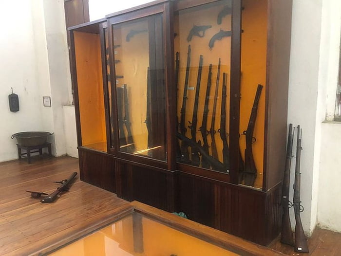 armário antigo de madeira com armas guardadas dentro