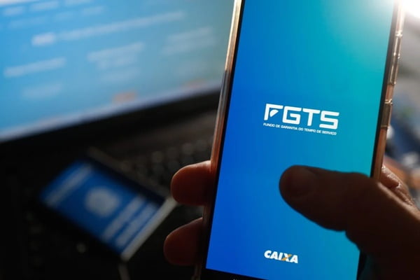 foto mostra uma pessoa segurando um celular com a tela aberta no aplicativo do FGTS digital