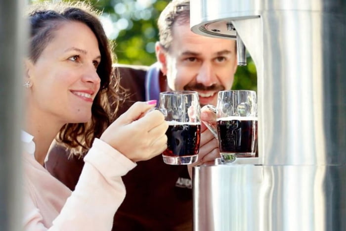 foto colorida de casal com copo de cerveja na mão
