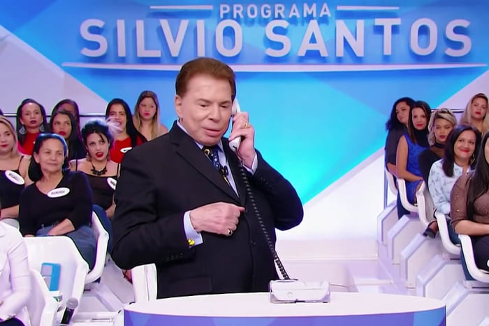 Silvio Santos ao telefone no palco de seu programa - Metrópoles