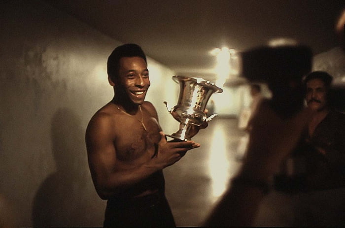Jogador de futebol brasileiro Pelé, do New York Cosmos, posa com um troféu em 1977 - Metrópoles