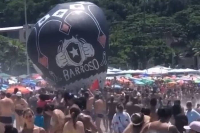 balão em cima de diversas pessoas em praia - metrópoles
