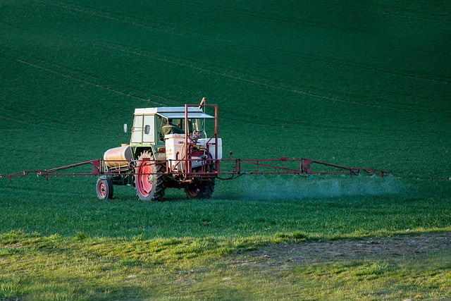 Imagem colorida de trator espalhando agrotóxico sobre um campo verde pib agropecuária