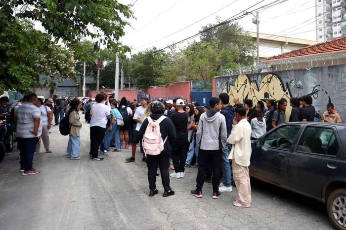 Foto colorida mostra estudantes reunidos em frente a Escola Thomazia Montoro