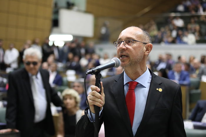 Fotografia colorida mostra deputado Paulo Fiorilo, homem careca usando óculos, discursando ao microfone no plenário da Alesp - Metrópoles