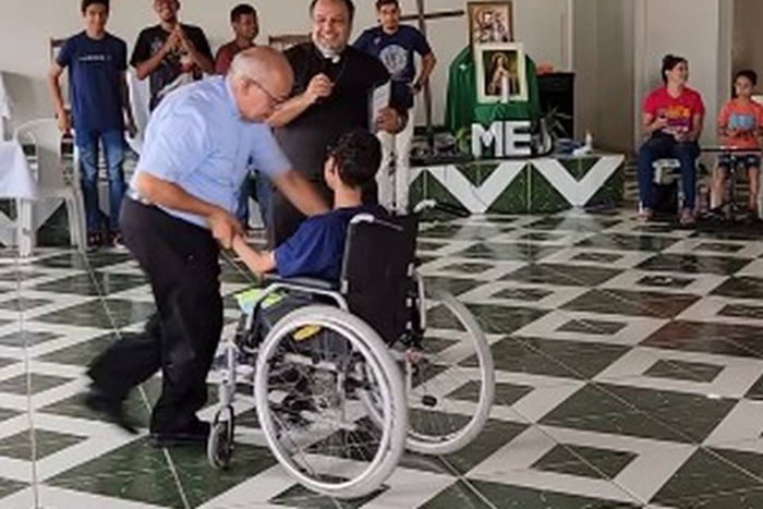 Imagem mostra diácono dançando com jovem em cadeira de rodas - Metrópoles