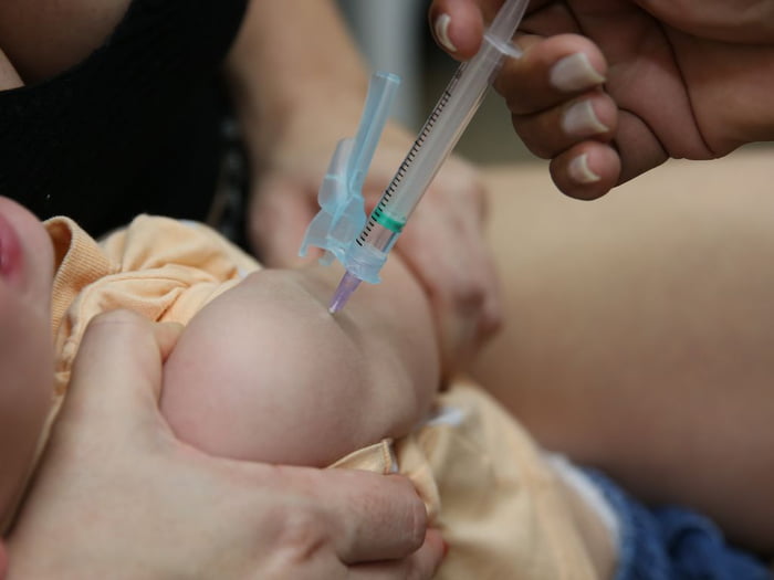 criança pequena recebe vacina no braço - metrópoles