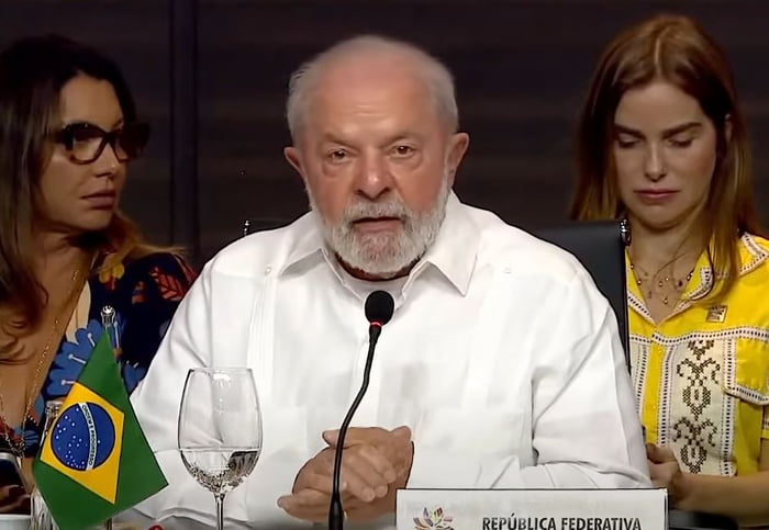 Imagem colorida mostra Lula de camisa branca em discurso