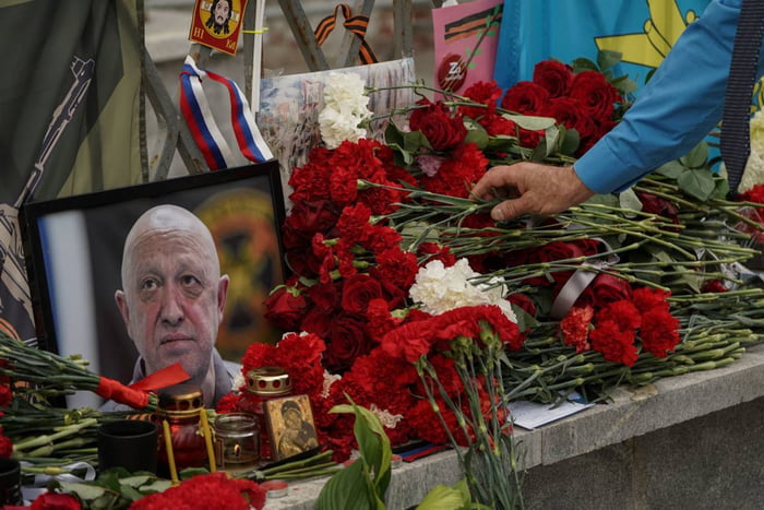 imagem colorida mostra quadro de Prigozhin, líder do grupo Wagner, em meio a rosas em tributo a sua morte - Metrópoles - Rússia
