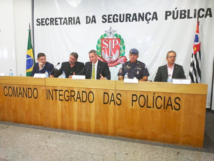 Imagem colorida mostra o secretário de segurança de São Paulo, Guilherme Derrite, no centro de uma mesa de cinco homens, integrantes da cúpula da segurança do estado - Metrópoles