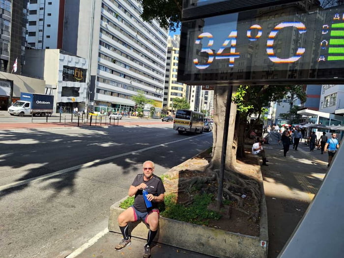 foto colorida de homem com garrafa de água na Avenida Paulista, perto de termômetro que marca 34 graus - Metrópoles
