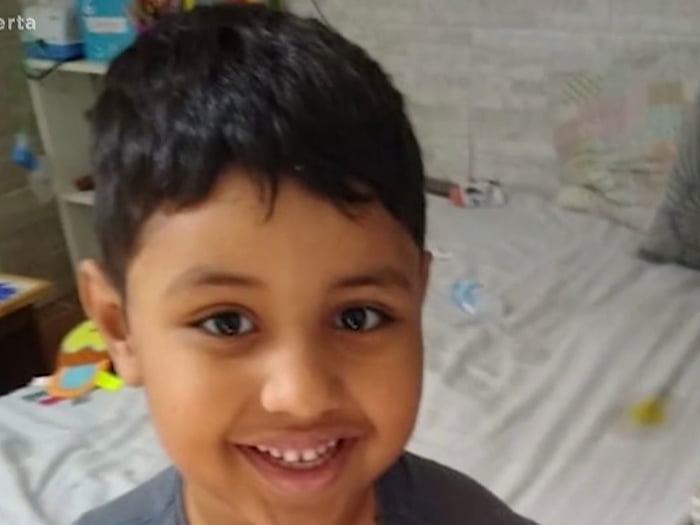 Foto colorida de garoto moreno sorrindo - Metrópoles