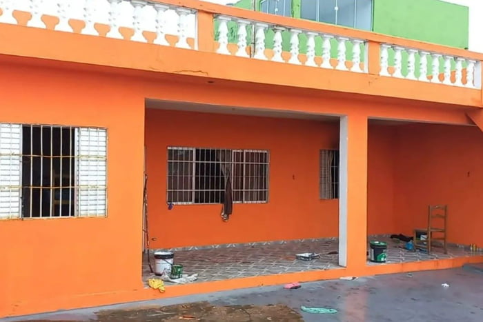 Imagem colorida mostra uma casa laranja com roupas espalhadas pelo chão; no local, um homem de 26 anos esquartejou um pedreiro - Metrópoles