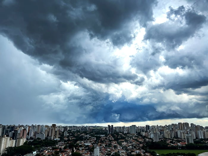 Imagem colorida mostra horizonte de São Paulo, cheio de prédios, com tempo fechado para chuva acima - Metrópoles