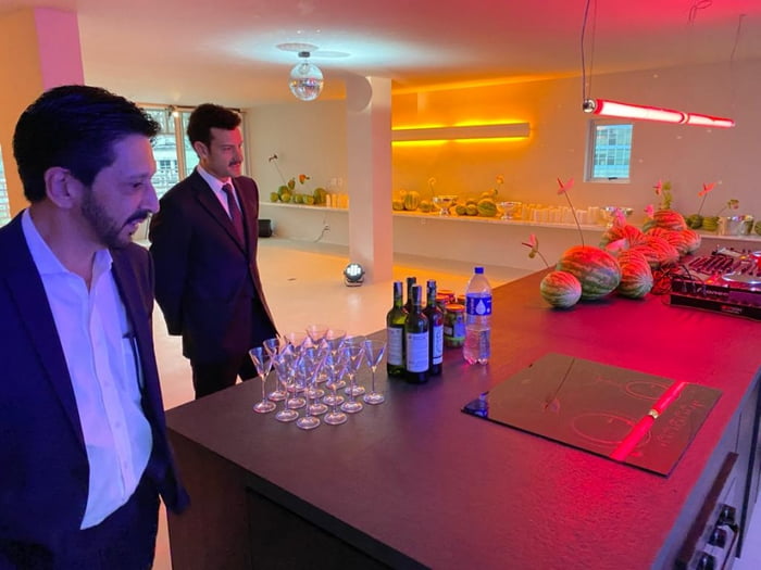 Imagem colorida mostra Ricardo Nunes, homem branco, de cabelo e barba pretos, terno azul e camisa branca, em uma sala de festas minimalista com luzes neons, de frente para uma mesa com copos e garrafas de bebidas - Metrópoles
