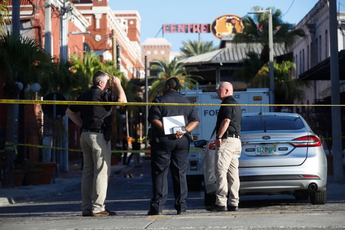 Imagem colorida mostra policiais onde tiroteio matou dois e feriu pelo menos 18 em Tampa, nos EUA - Metrópoles