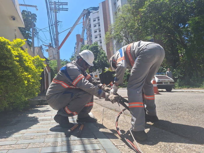 Imagem mostra trabalhadores da Enel esticando cabos. Procon exige esclarecimentos da empresa - Metrópoles