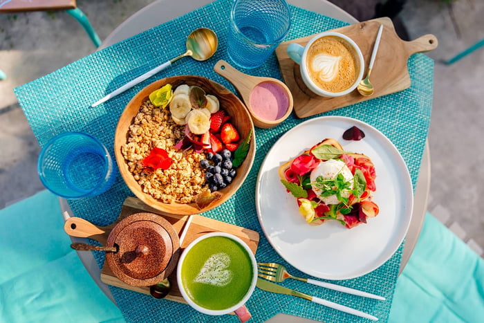 Foto colorida de bowls com cereais, frutas, café e suco verde - Metrópoles