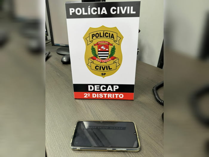 Imagem de placa com distintivo da Polícia Civil e um celular - Metrópoles
