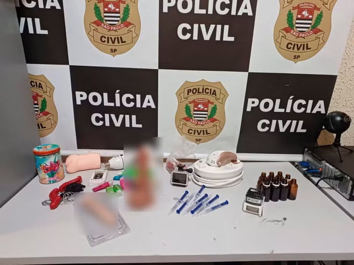 Imagem de objetos, entre brinquedos sexuais e armas, sobre mesa em delegacia - Metrópoles