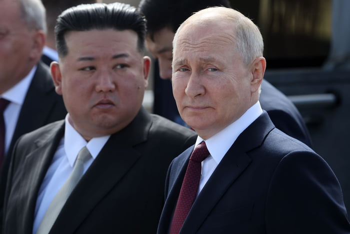 Imagem colorida mostra Vladimir Putin em primeiro plano e Kim Jong-un ao fundo - Metrópoles