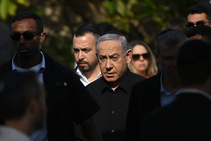 Imagem colorida mostra Benjamin Netanyahu usando roupa preta e chapéu tradicional judaico - Metrópoles