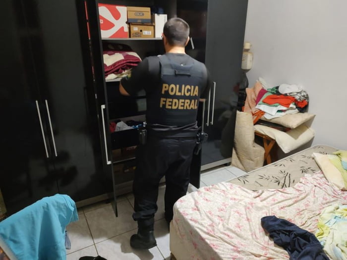 Imagem de policial federal dentro de quarto, olhando para guarda roupas - Metrópoles