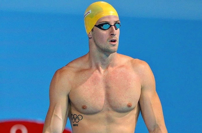 imagem dolorida mostra o nadador Magnussen de touca amarela
