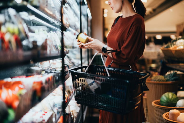 mulher escolhendo produto no supermercado