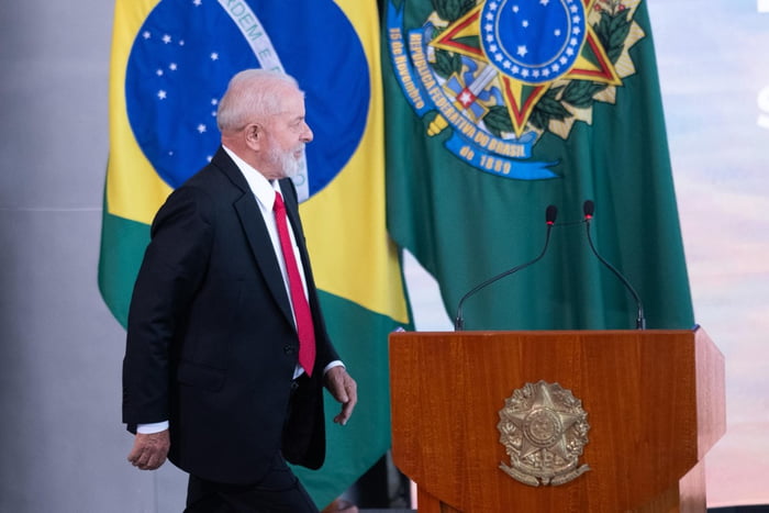 Imagem colorida do presidente Lula, no Planalto, em frente à bandeira do Brasil desenrola - Metrópoles