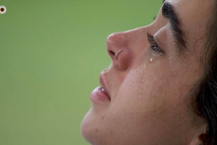 Mulher chorando com fundo verde - Metrópoles