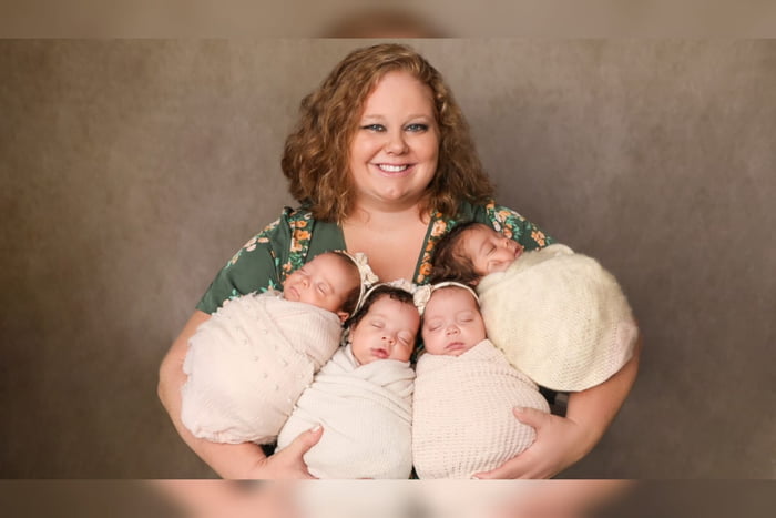 Foto mostra mulher branca ao lado de quatro bebês em ensaio fotográfico. Ela é mãe de quadrigêmeos