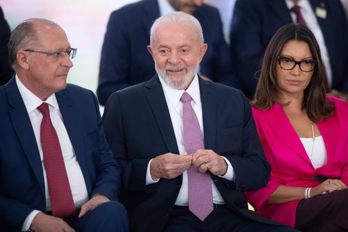Imagem colorida do vice-presidente Geraldo Alckmin sentado ao lado do presidente Lula e da primeira-dama Janja - Metrópoles