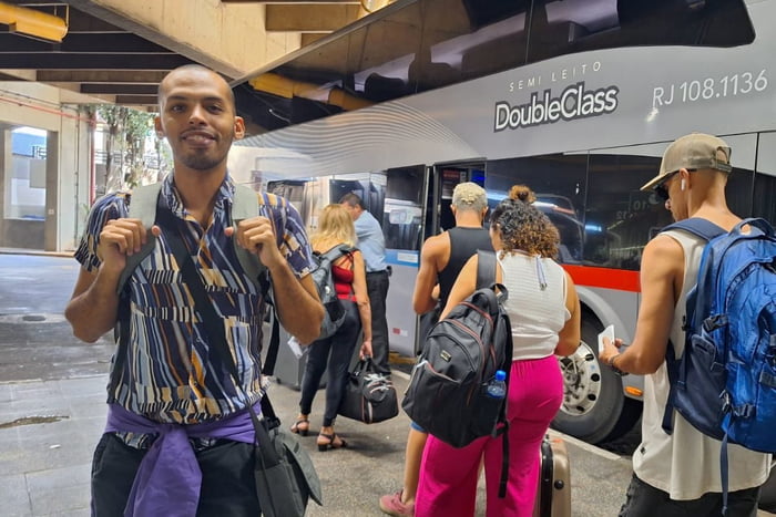 foto colorida de fãs de Madonna embarcando de ônibus, na Rodoviária do Tietê, para o Rio de Janeiro; no detalhe, o fã Carlos Rodrigues - Metrópoles