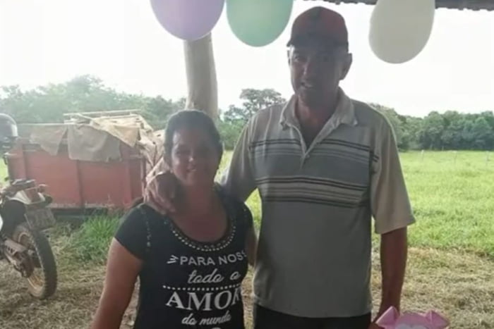Casal maduro de homem e mulher posam para foto com balões ao fundo