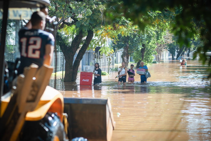 Pessoas são vistas com águas na cintura após a enchente do Rio Guaíba inundarem as ruas da cidade de Porto Alegre no Rio grande do Sul RS - Metrópoles