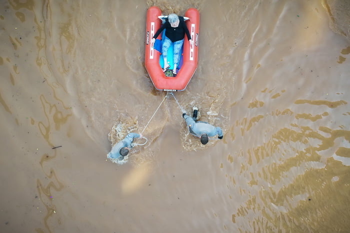 Voluntários ajudam mulher após a enchente do Rio Guaíba inundarem as ruas da cidade de Porto Alegre no Rio grande do Sul RS - Metrópoles