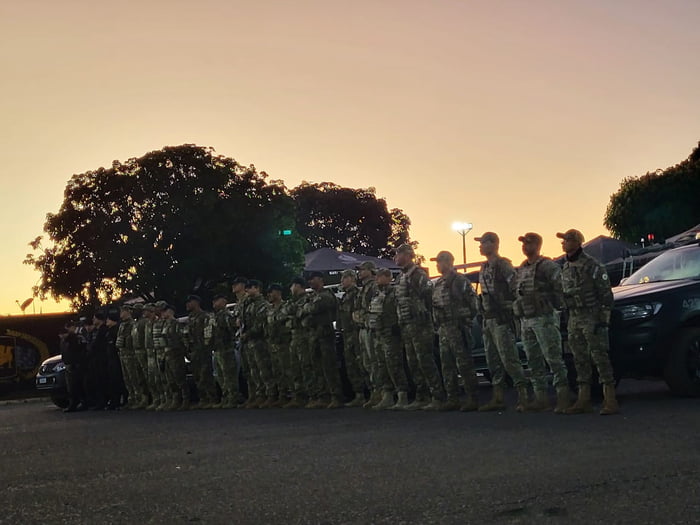 Fotos coloridas tiradas no início da manhã de homens fardados com uniforme da polícia militar do df