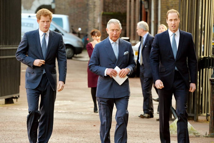 Imagem colorida- Rei Charles no meio, Harry na esquerda e William na direita.